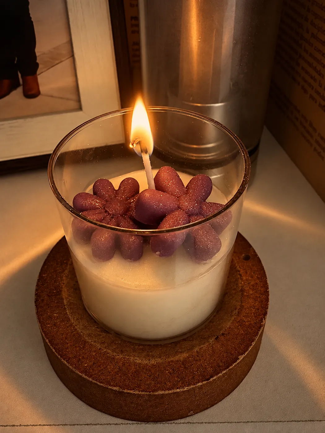 Vela en vaso con flores de cera encendida